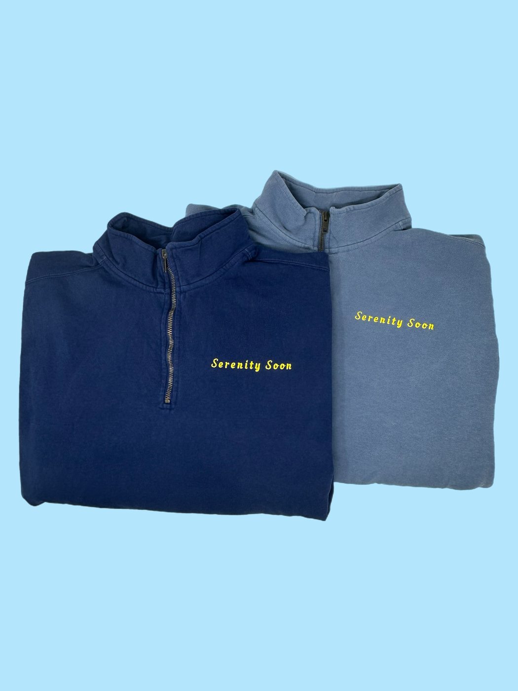 Two embroidered quarter-zip sweatshirts in navy and blue
