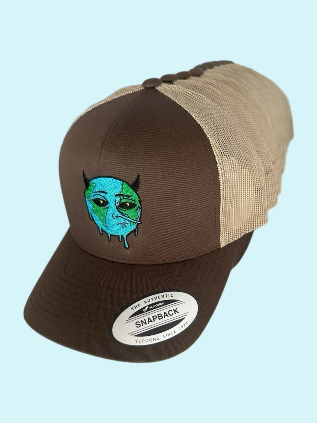 nefarious character logo embroidered on a brown and khaki trucker cap