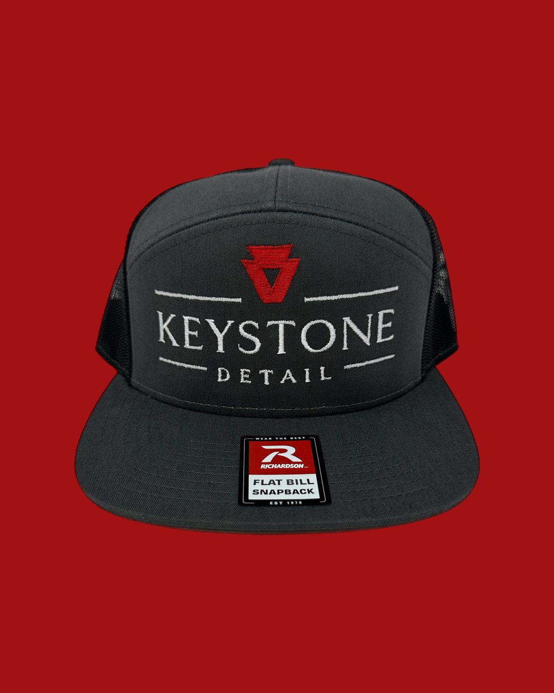Keystone Detail embroidered 7-panel cap on a red background